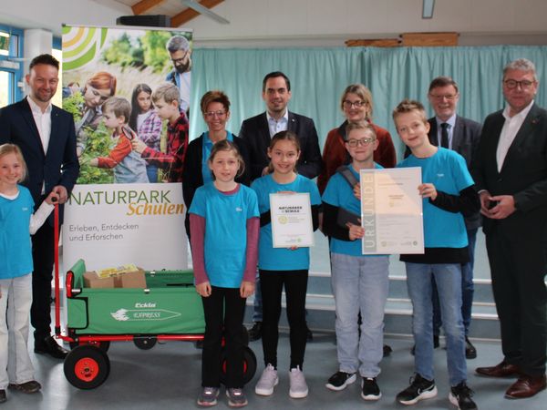 Gruppe von Menschen steht zusammen und feiert die Naturpark-Schule in Rischenau