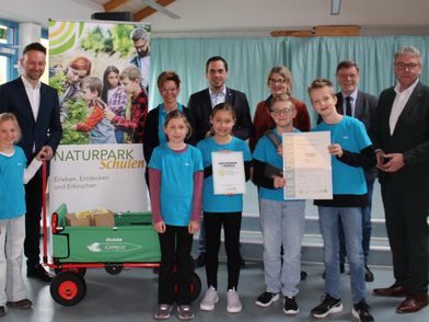 Gruppe von Menschen steht zusammen und feiert die Naturpark-Schule in Rischenau