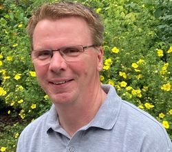 Das Bild zeigt den freundlich lachenden Naturparkführer Bernhard Aufenanger. Er hat helles kurzes Haar und trägt eine Brille sowie ein graues T-Shirt.