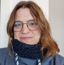 Das Foto zeigt Anja Bonte. Sie hat braune lange Haare und trägt eine Brille.