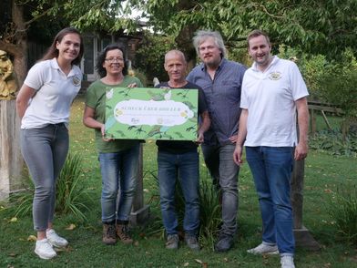 Fünf Personen halten einen großen Spendenscheck hoch