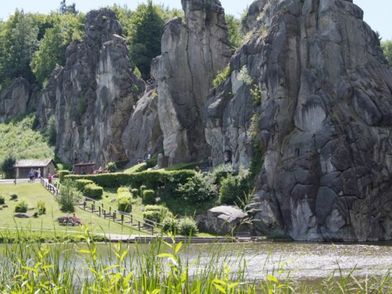 Die Externsteine im Sonnenschein, davor der Teich