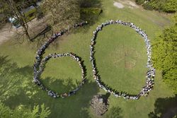 Alle Schüler der Naturpark-Schule Bildungshaus Weerth-Schule haben eine zum Jubiläum des Naturparks eine 60 aufgestellt. Blick von oben auf die Kinder. 