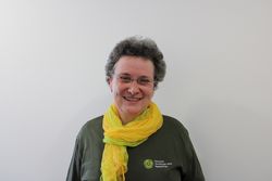 Das Bild zeigt Naturparkführerin Anke Nitschke. Sie hat kurze lockige Haare, trägt eine Brille und ein gelbes Tuch.