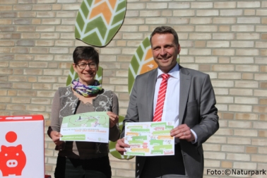 Oliver Bekiersch von der Sparkasse Paderborn Detmold und Birgt Hübner, Geschäftsführerin Naturpark präsentieren die neue Hermann-Rallye