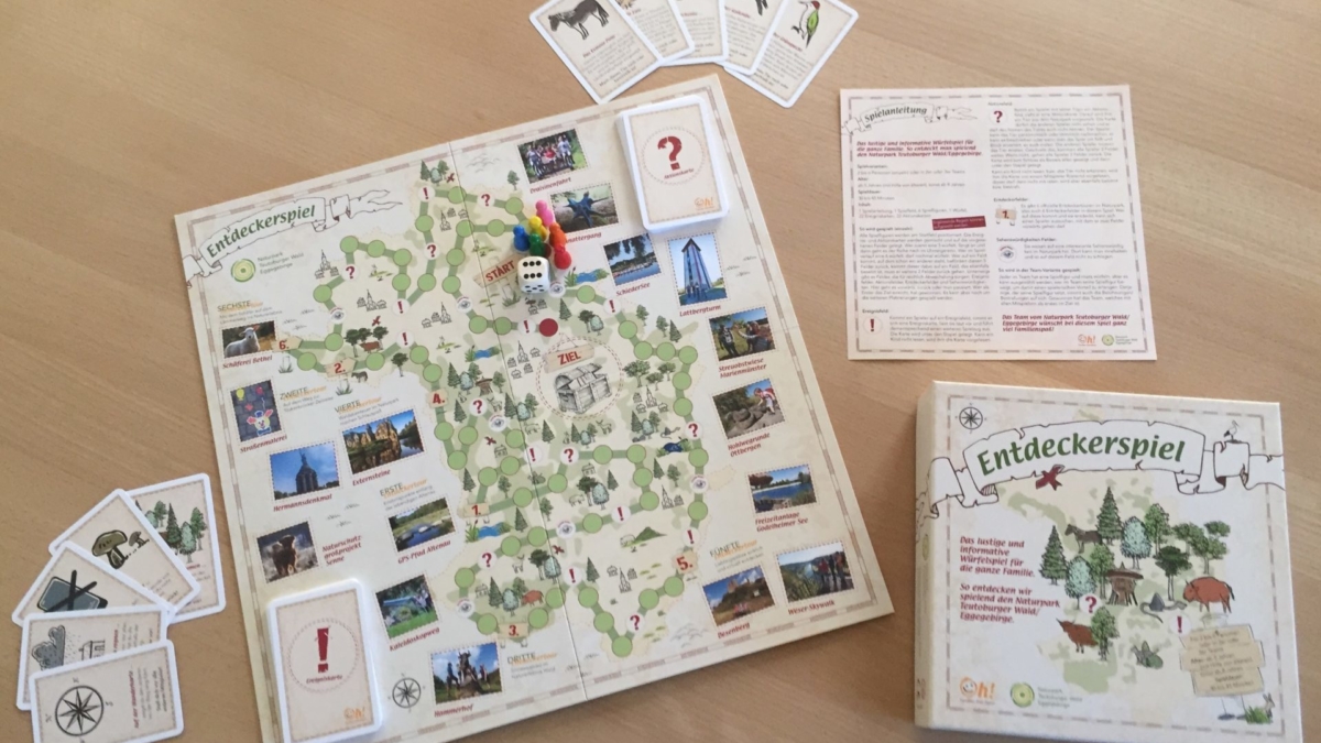 Ausgepacktes Entdeckerspiel mit Brett, Würfel, Spielfiguren, Spielanleitung und Karten